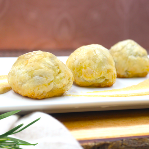 Three baked goods on a white plate with a blurred background