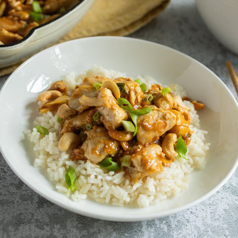 White bowl with chicken and rice on a gray surface
